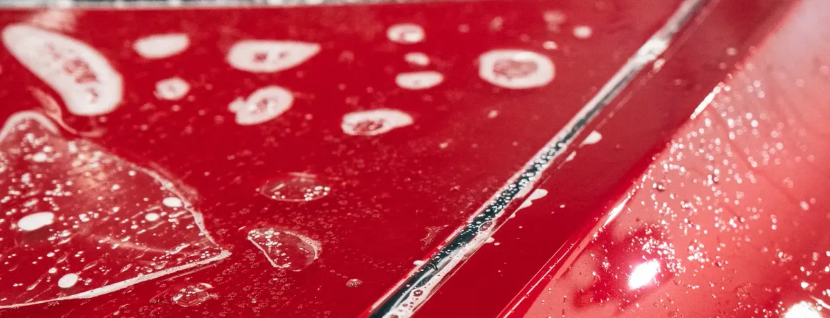 Application d'un revêtement protecteur sur la carrosserie rouge d'un véhicule