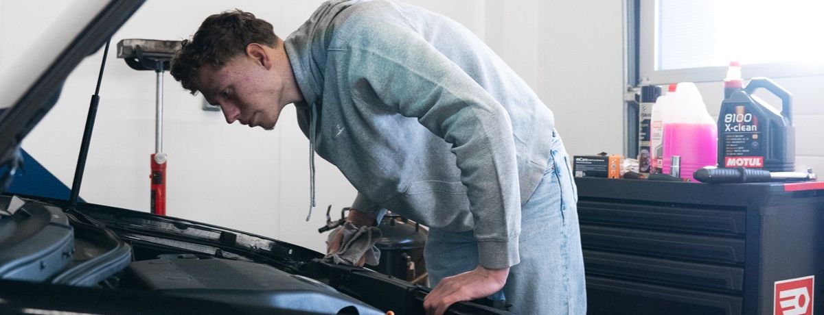 Mécanicien inspectant le moteur avant une intervention sur le circuit de refroidissement