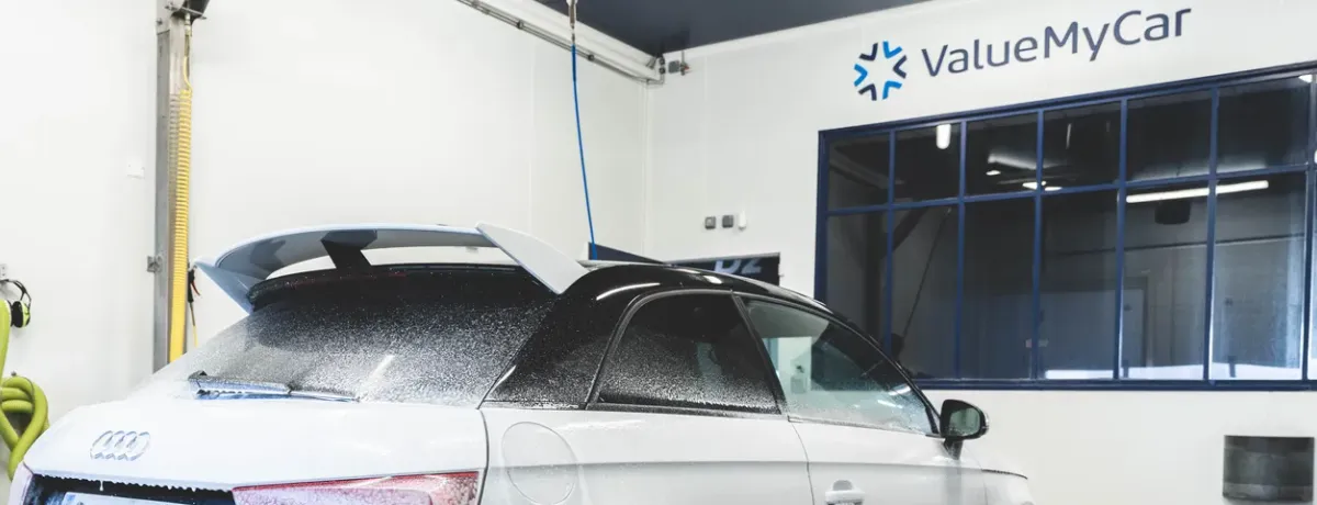 Voiture noire garée devant l'entrée d'un centre ValueMyCar