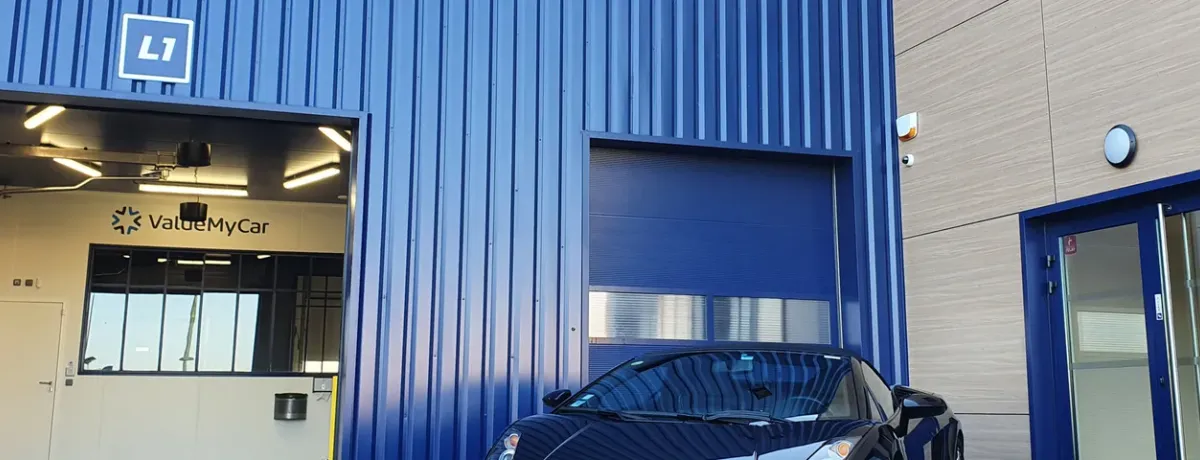 Façade d'un centre ValueMyCar avec box mécanique ouvert et voiture garée devant