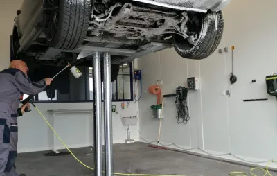 Dessous de caisse d'un véhicule levé sur pont, nettoyé au jet dans un centre ValueMyCar