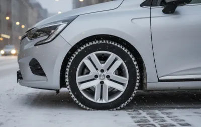 Roue avant d'une voiture circulant sous la neige en ville