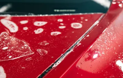 Application d'un revêtement protecteur sur la carrosserie rouge d'un véhicule