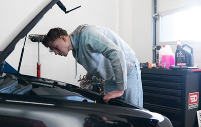 Mécanicien inspectant le moteur avant une intervention sur le circuit de refroidissement