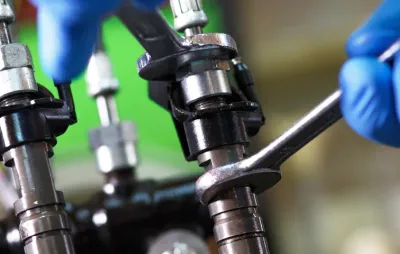 Mécanicien démontant un injecteur de carburant à la clé sur un moteur