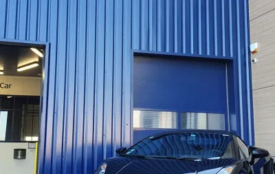 Façade d'un centre ValueMyCar avec box mécanique ouvert et voiture garée devant