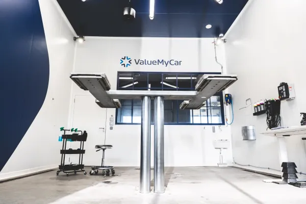 Box detailing chez ValueMyCar avec outillage complet et pont de levage en position haute